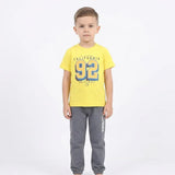 طقم قطعتين تيشرت رسمة ارقام كالفورنيا و بنطلون طباعه واستك من الاسفل اولادي تيشرت براسولا قطن وبنطلون سمر ميلتون اصفر صيفي من باجي - p16